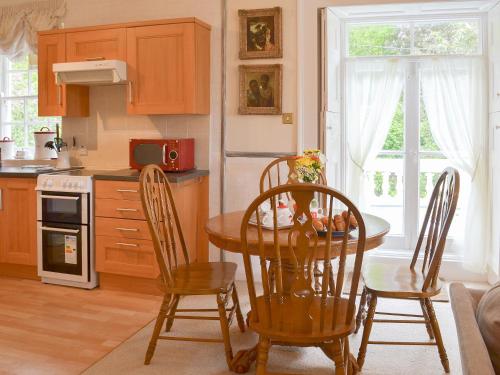 a kitchen with a wooden table and chairs in a kitchen at Caradon Apt - Cv14 in Saint Cleer