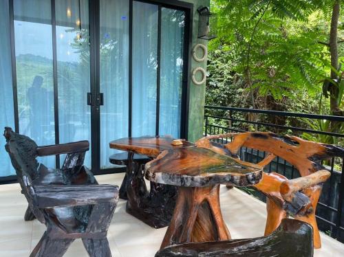 a wooden table and two chairs on a porch at Sea Smile Green View Pool Villa KRABI Klong Muang in Klong Muang Beach