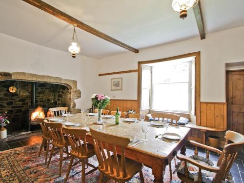 uma sala de jantar com uma mesa e cadeiras e uma lareira em Manor House em Uny Lelant