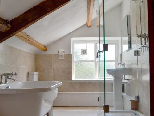 a bathroom with a sink and a toilet and a tub at The Mill Farmhouse in Llandybie