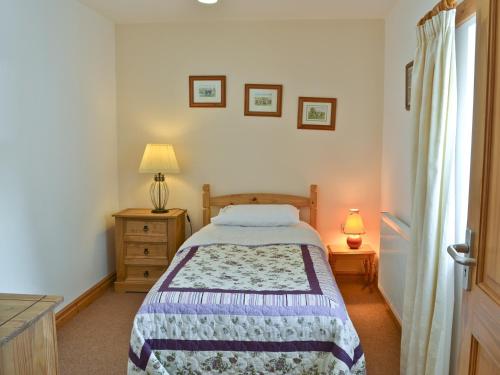 um quarto com uma cama, uma cómoda e uma janela em Alices Cottage em Lanehead