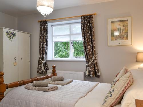 Schlafzimmer mit einem Bett und einem Fenster in der Unterkunft Burrills View in Horderley