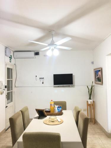 a dining room with a table and a ceiling fan at Casa De Alquiler Temporario, Vialibres Chascomús in Chascomús