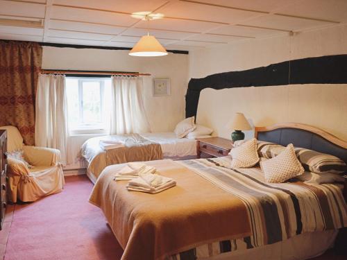 um quarto de hotel com duas camas e uma janela em The Farmhouse em Newent