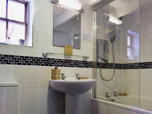 a bathroom with a sink and a shower at Castleton House in Staithes