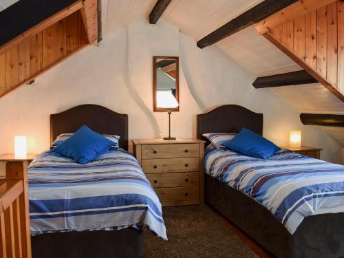 a bedroom with two beds and a dresser at Castleton House in Staithes