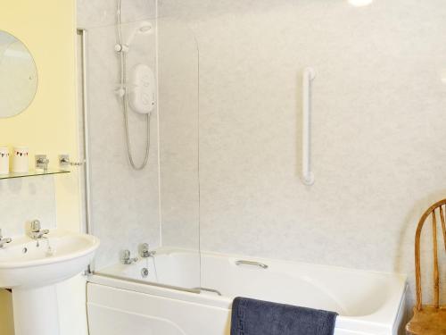 a bathroom with a white tub and a sink at Stable Cottage 1 in Rudston