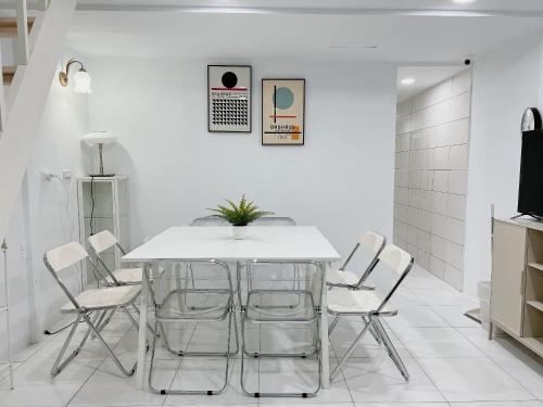 a white dining room with a white table and chairs at Soda White Tainan Homestay in Tainan