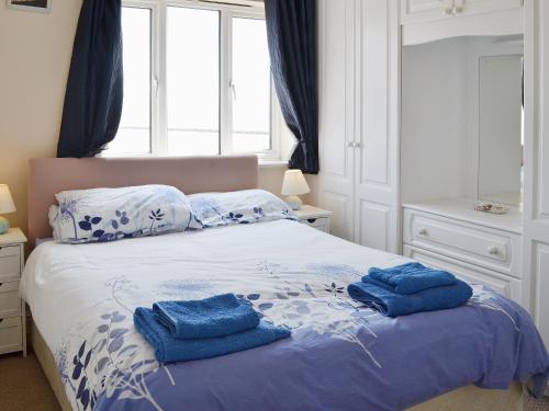 a bedroom with a bed with blue towels on it at Bay View in Clacton-on-Sea
