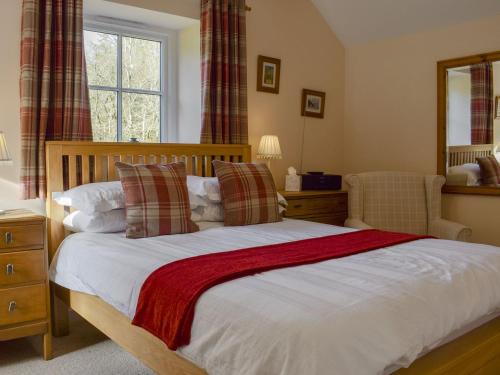 a bedroom with a large bed and a mirror at Bonnies Bothy in Port of Menteith