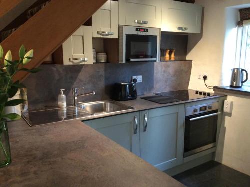a kitchen with a sink and a stove at Garries Cottage in Bassenthwaite