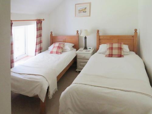 two twin beds in a bedroom with a window at Garries Cottage in Bassenthwaite