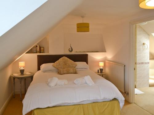 a bedroom with a white bed with towels on it at Otters in Wroxham