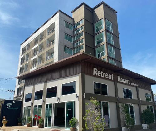 a tall building with a redici research building at Retreat Resort Pattaya in Nong Prue