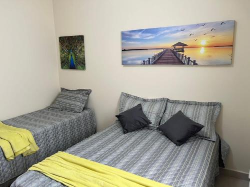 a bedroom with two beds and a picture of a pier at Casa em Brotas Turismo de aventura in Brotas