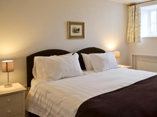 a bedroom with a large white bed with white pillows at The Hayloft - Nab in Aynho