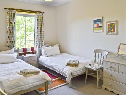 sypialnia z 2 łóżkami pojedynczymi i oknem w obiekcie The Cottage w mieście Girvan