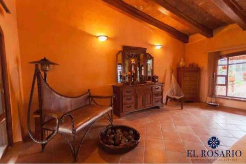 a room with a chair and a dresser and a mirror at Quinta El Rosario maravilloso lugar in Lagos de Moreno