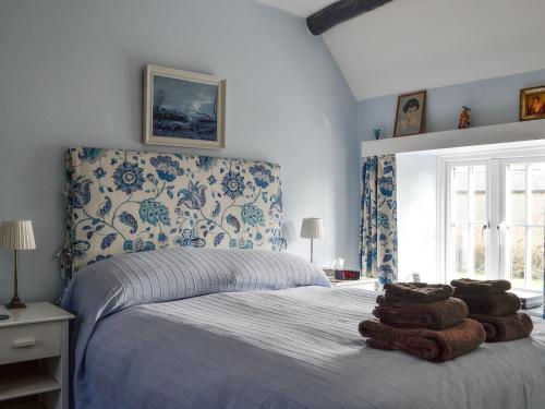 1 dormitorio con 1 cama con toallas en Weavers Cottage, en Stow on the Wold