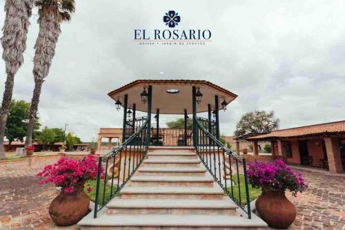 a set of stairs leading to a gate with flowers at Quinta El Rosario maravilloso lugar in Lagos de Moreno