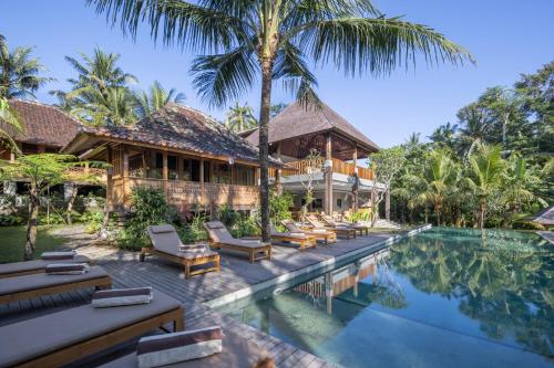 eine Villa mit einem Pool und einem Resort in der Unterkunft RUMAH KAYU RESORT in Ubud