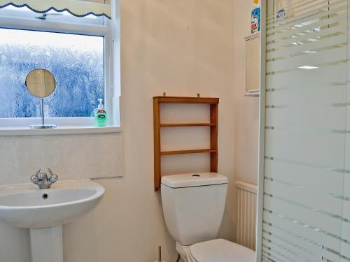 a bathroom with a toilet and a sink and a window at The Beach Hut in Bridlington