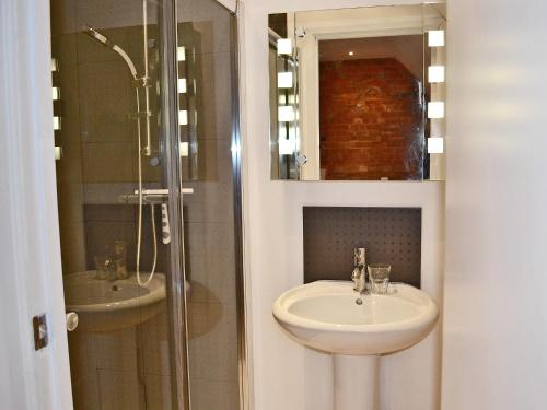 a bathroom with a sink and a shower at The Lodge At The Granary in Alderton