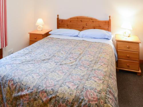 um quarto com uma cama grande e 2 mesas de cabeceira em Horsemans em John o' Groats