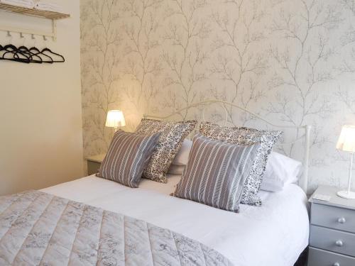 a bedroom with a white bed with pillows on it at Melandra in Smeafield