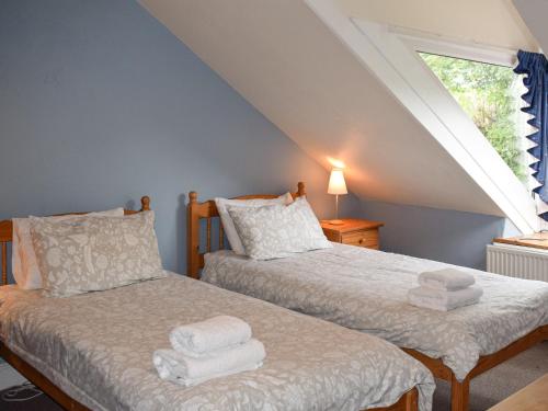 2 Einzelbetten in einem Zimmer mit Fenster in der Unterkunft Lake View Apartment in Bowness-on-Windermere