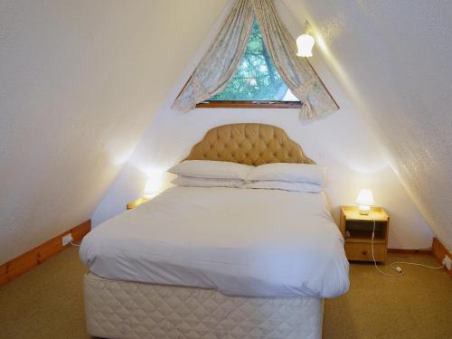 a bedroom with a white bed with a window at Bay View in Kingsdown