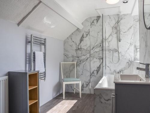 a bathroom with a chair and a sink and a shower at Church View in Lynmouth