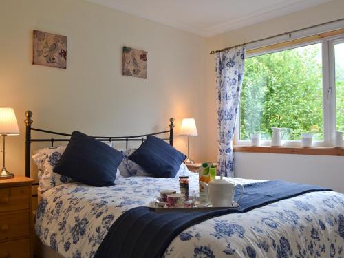 a bedroom with a bed with a tray on it at Tigh Nan Allt in Dull