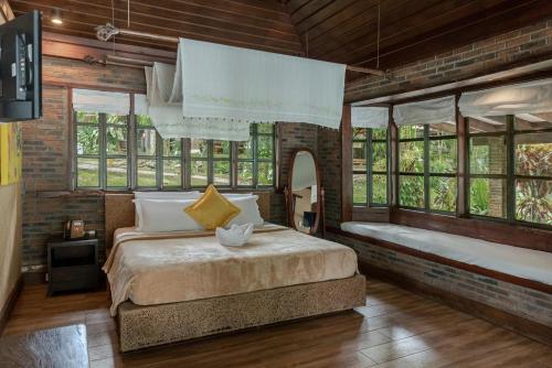 a bedroom with two beds in a room with windows at Chema's by the Sea in Samal