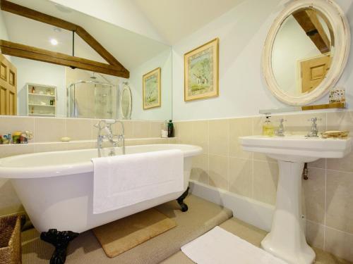 a bathroom with a tub and a sink at The Stables At Weedon Hill Farm in Church Stowe