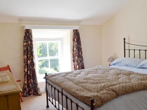 een slaapkamer met een bed en een raam met gordijnen bij Belle Vue-ukc778 in Eggleston