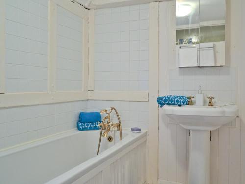 y baño blanco con lavabo, bañera y lavamanos. en Rose Cottage en Hythe