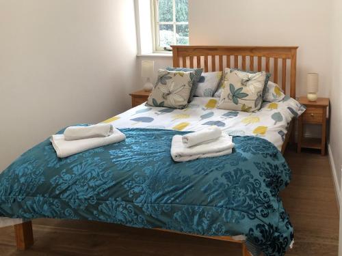 ein Schlafzimmer mit einem Bett mit Handtüchern darauf in der Unterkunft Princess Cottage in Martin