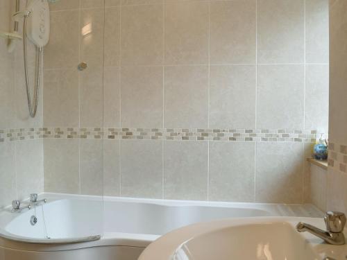 a bathroom with a tub and a toilet and a sink at Ty Nant in Llanon