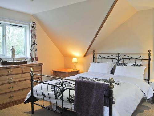 a bedroom with a black bed and a window at The Hurstings in Bridgnorth