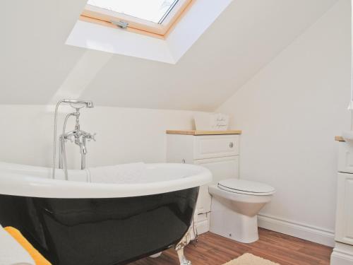 a bathroom with a bath tub and a toilet at The Hurstings in Bridgnorth