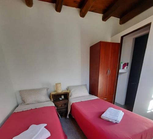 2 camas en una habitación con sábanas rojas en Mono ambiente Loria en Luján de Cuyo