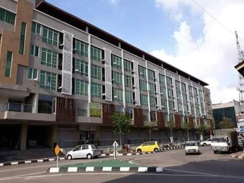 een groot gebouw met auto's geparkeerd voor het bij d arissa house in Kota Bharu