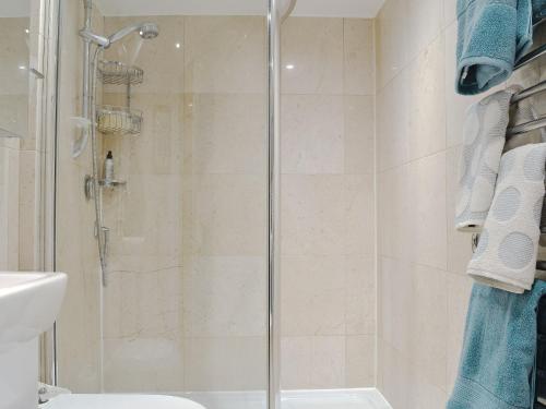 a shower with a glass door in a bathroom at Hurdlemakers Loft in Upper Brailes