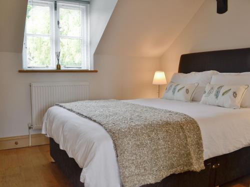 a bedroom with a large bed and a window at Hurdlemakers Loft in Upper Brailes