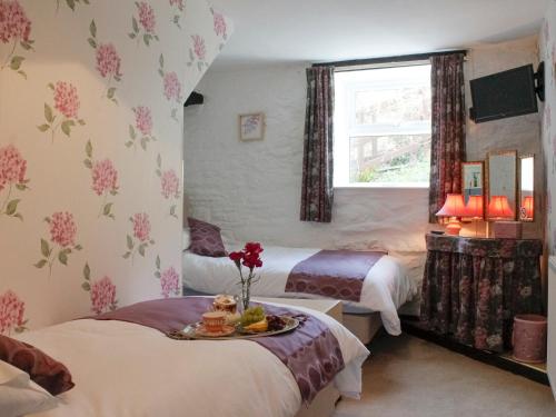 1 dormitorio con 2 camas y ventana en Dairy Cottage en Barnstaple