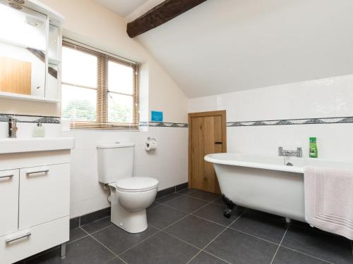 a bathroom with a tub and a toilet and a sink at Brook House in Mathon