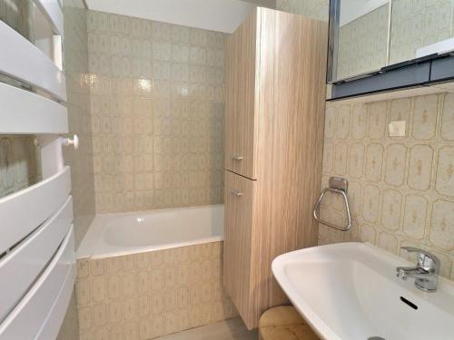une salle de bain avec une baignoire et un lavabo et une baignoire dans l'établissement 2 Pièces Skis aux Pieds - Balcon, Animaux Ok - FR-1-182-253, à Les Allues