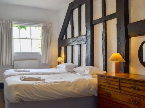 um quarto com uma cama grande e uma cabeceira em madeira em Cronkhill Farmhouse em Wroxeter