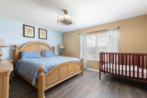 a bedroom with a bed and a window and a crib at Windsor Hills Resort 2 Miles to Disney 6-Bedroom 4-Bathrooms Villa with Private Pool and Spa in Orlando